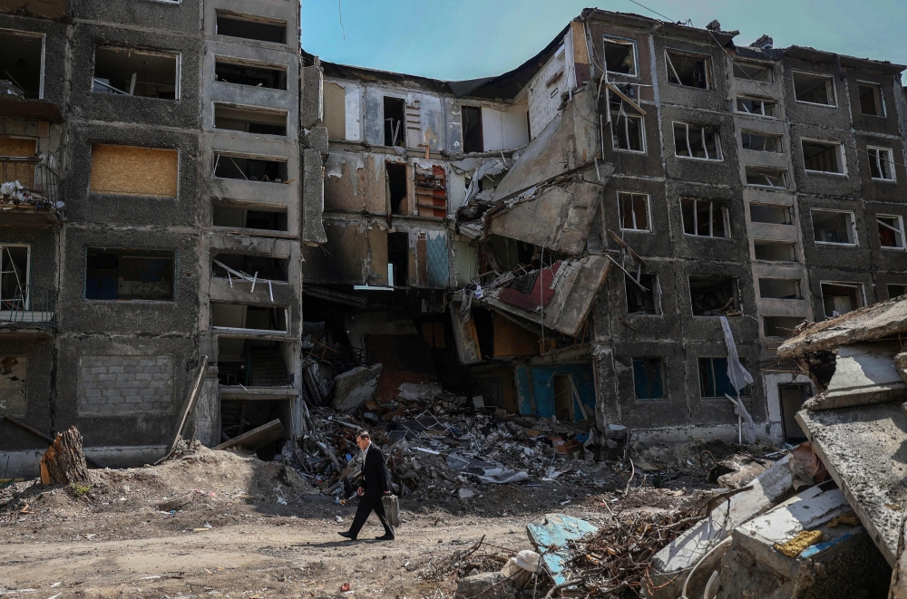 A local resident walks past heavily damaged buildings in the town of Selydove, Donetsk region, on April 12, 2024. Photo by Anatolii STEPANOV / AFP.