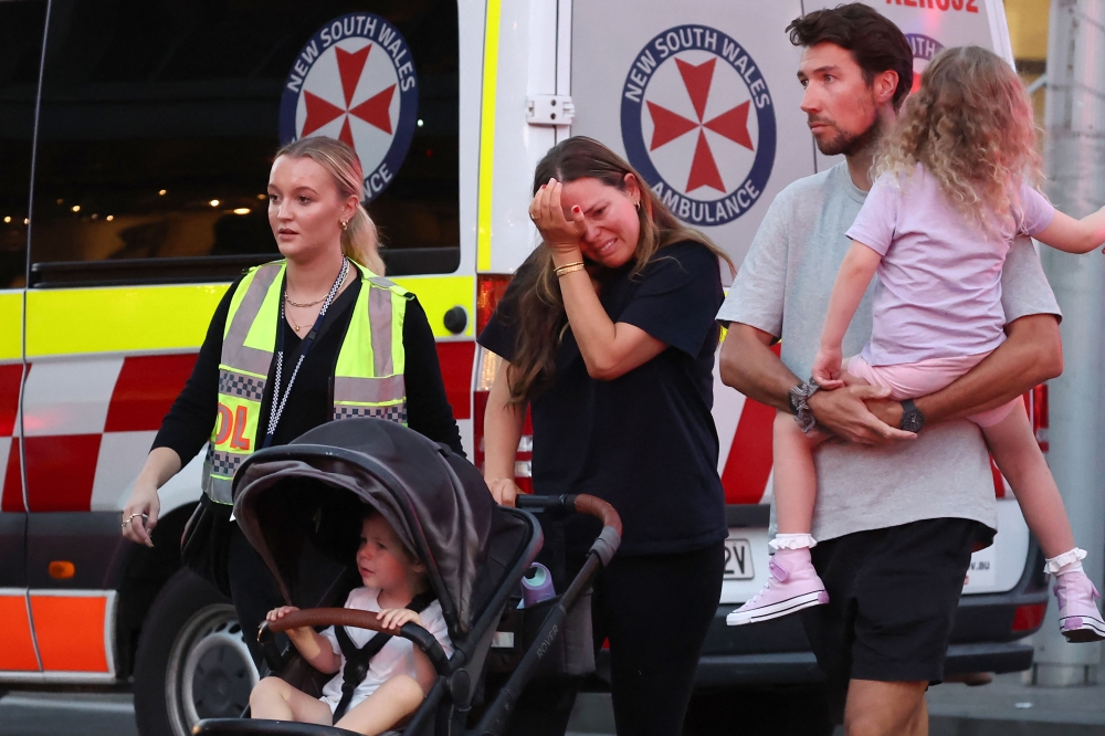 A woman cries as she comes out of the Westfield Bondi Junction shopping mall after a stabbing incident in Sydney on April 13, 2024. (Photo by David GRAY / AFP)
