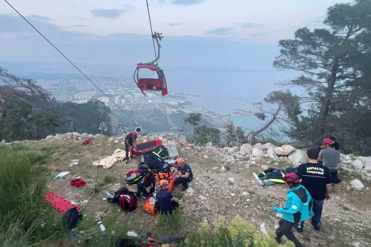 This handout photograph taken and released on April 12, 2024 by Turkish news agency DHA (Demiroren News Agency) shows rescue teams conducting a rescue operation and helping injured people after a cable car cabin crashed into a fallen cable pole in Konyaalti district of Antalya. (Photo by Handout / DHA (Demiroren News Agency) / AFP)