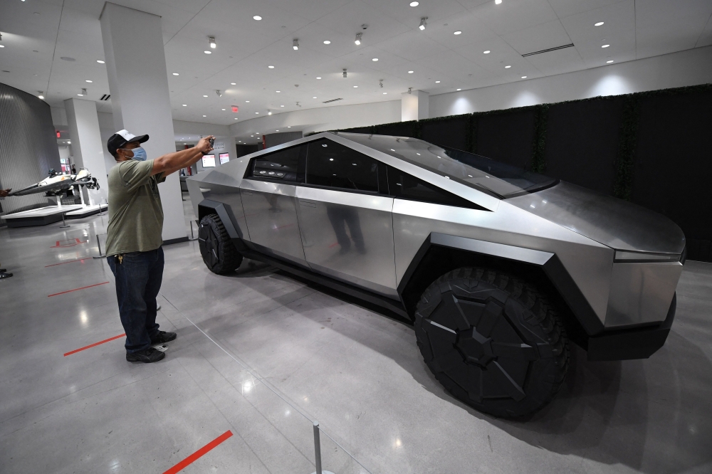 (FILES) Visitors view the Tesla Cybertruck at the recently reopened Petersen Automotive Museum in Los Angeles, California, July 1, 2020. (Photo by Robyn Beck / AFP)
