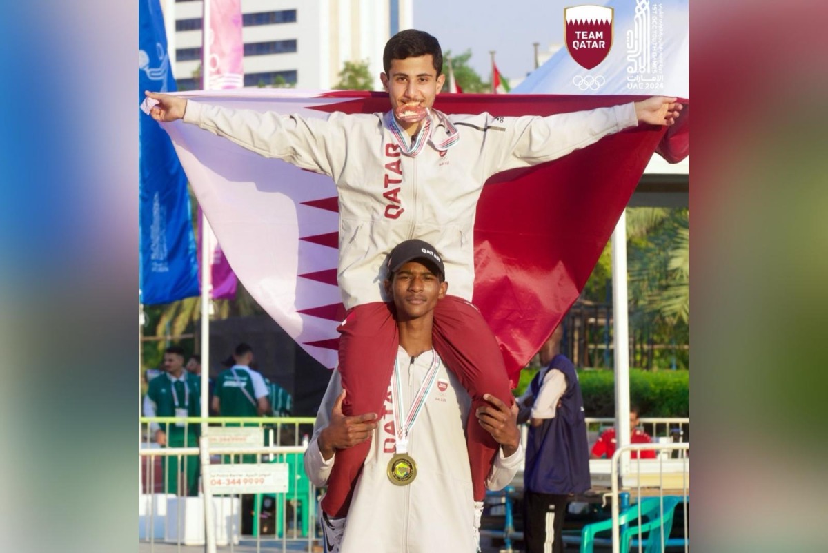 Qatar’s gold medal winner Rakan Rashidi lifts teammate Hamza Hashem, bronze medal winner, on his shoulders after dominating   the triple jump event.   