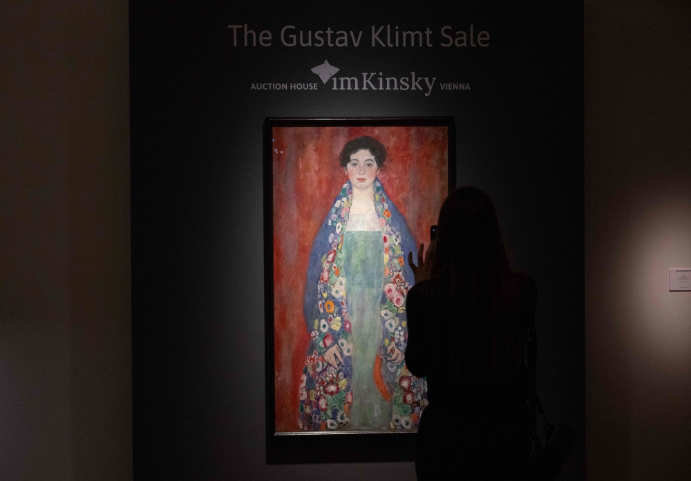 (FILES) A visitor takes a picture of the rediscovered painting of a young female 'Portrait of Miss Lieser' by the Austrian painter Gustav Klimt on a display at the im Kinsky auction house in Vienna, Austria on April 16, 2024. (Photo by Joe Klamar / AFP)
