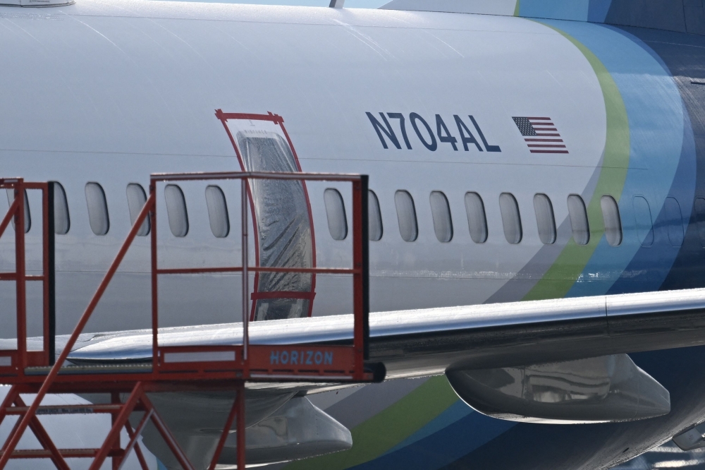 (FILES) The missing emergency door of Alaska Airlines N704AL, a 737 Max 9, which made an emergency landing at Portland International Airport on January 5 is covered and taped, in Portland, Oregon, on January 23, 2024. (Photo by Patrick T. Fallon / AFP)
