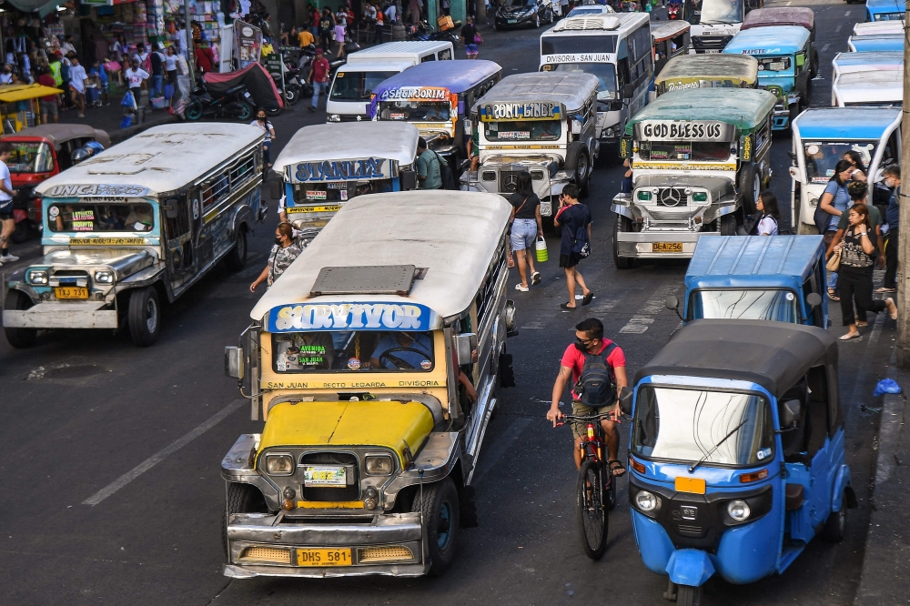 In this photo taken on April 5, 2024, jeepneys commute along a street in Manila. (Photo by Ted ALJIBE / AFP)