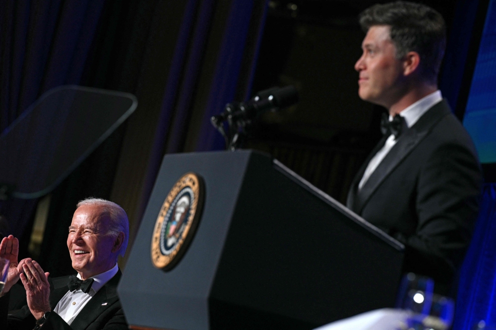US President Joe Biden laughs as US comedian Colin Jost (R) speaks during the White House Correspondents' Association (WHCA) dinner at the Washington Hilton, in Washington, DC, on April 27, 2024. (Photo by Brendan Smialowski / AFP)