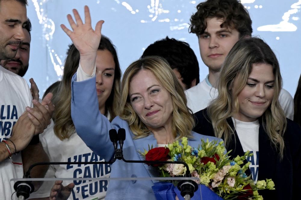 Italy's Prime Minister, Giorgia Meloni stands on stage surrounded by young people after her speech during the campaign meeting of the far-right party Fratelli d'Italia (Brothers of Italy) ahead of the European Elections, on April 28, 2024 in Pescara. (Photo by Tiziana FABI / AFP)

