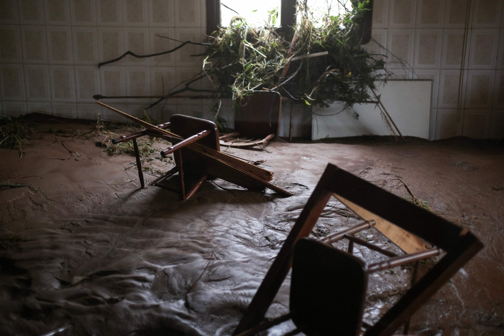 Chairs lie amid mud and debris inside a house partially destroyed by heavy rains in Sinimbu, in the Vale do Rio Pardo region of Rio Grande do Sul, Brazil, on May 1, 2024. (Photo by Anselmo Cunha / AFP)
