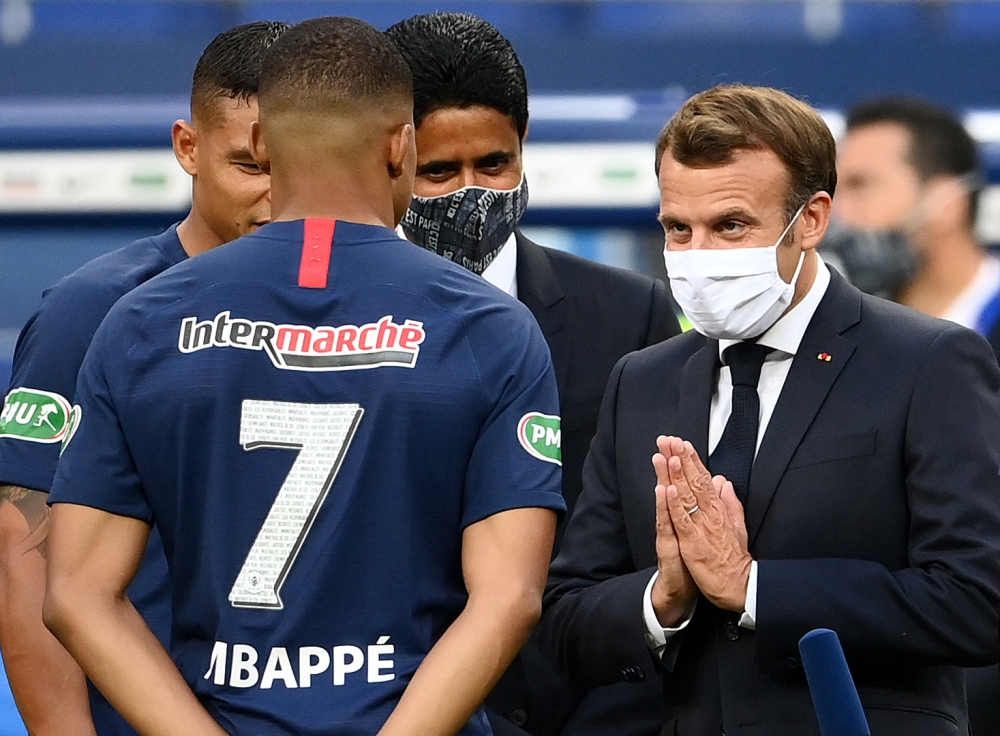 (Files) French President Emmanuel Macron (R) gestures as he speaks with Paris Saint-Germain's French forward Kylian Mbappe (L) at the Stade de France in Saint-Denis, outside Paris on July 24, 2020. (Photo by Franck Fife / AFP)