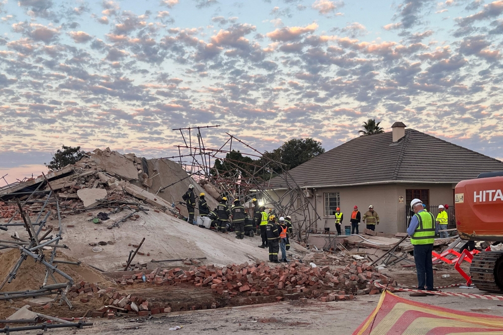 (Files) Rescue workers are seen at the scene of a collapsed building in George on May 7, 2024. (Photo by Willie van Tonder / AFP)

