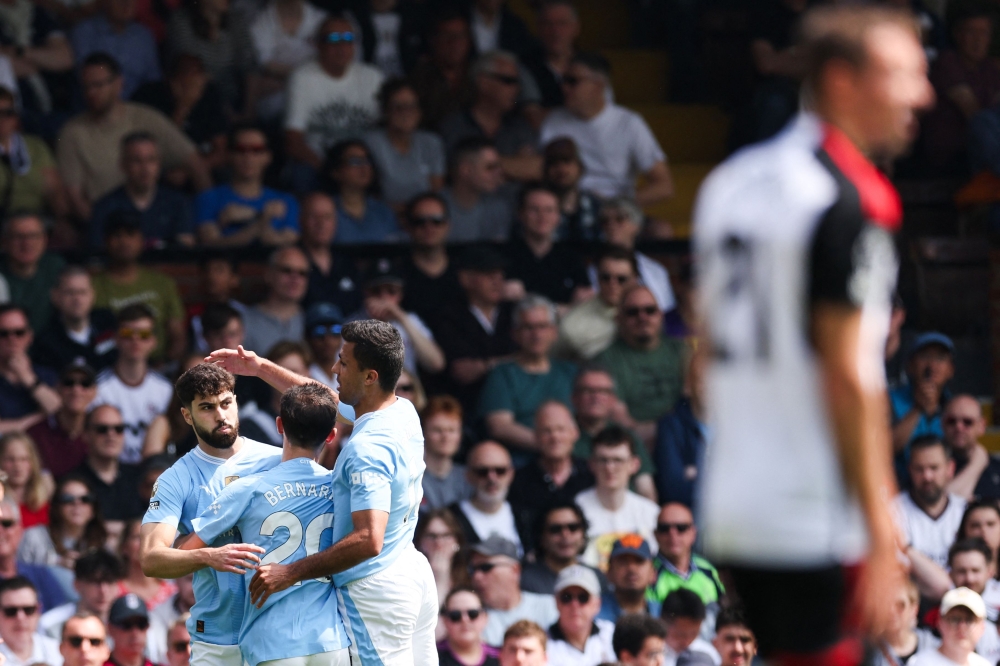 Manchester City's Croatian defender #24 Josko Gvardiol (L) celebrates scoring the team's first goal during the English Premier League football match between Fulham and Manchester City at Craven Cottage in London on May 11, 2024. (Photo by Adrian DENNIS / AFP)