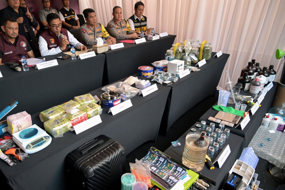 Wahyu Widada (2nd L, seated), head of Indonesia's criminal investigation agency, speaks as seized drugs from a police raid on a suspected drug lab are displayed during a press conference in Tibubeneng Village, Badung Regency on Indonesia's Bali island on May 13, 2024. (Photo by SONNY TUMBELAKA / AFP)
