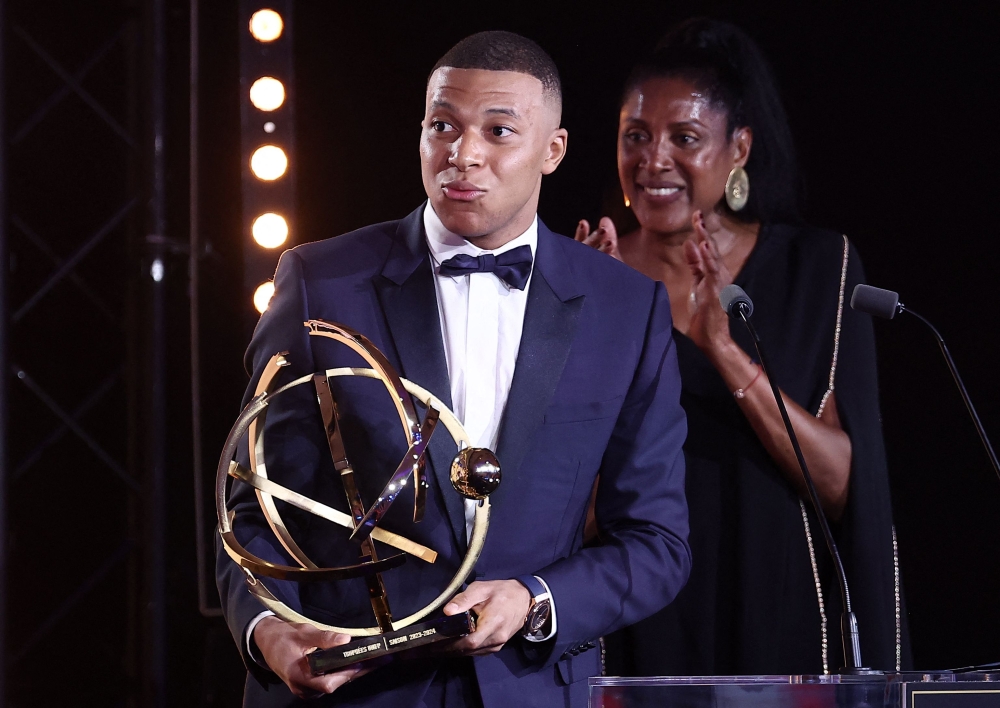 Paris Saint-Germain's French forward #07 Kylian Mbappe celebrates after receiving the Best Players Ligue 1 Award at the end of the TV show at the UNFP (French National Professional Football players Union) trophy ceremony, in Paris on May 13, 2024. (Photo by FRANCK FIFE / AFP)
