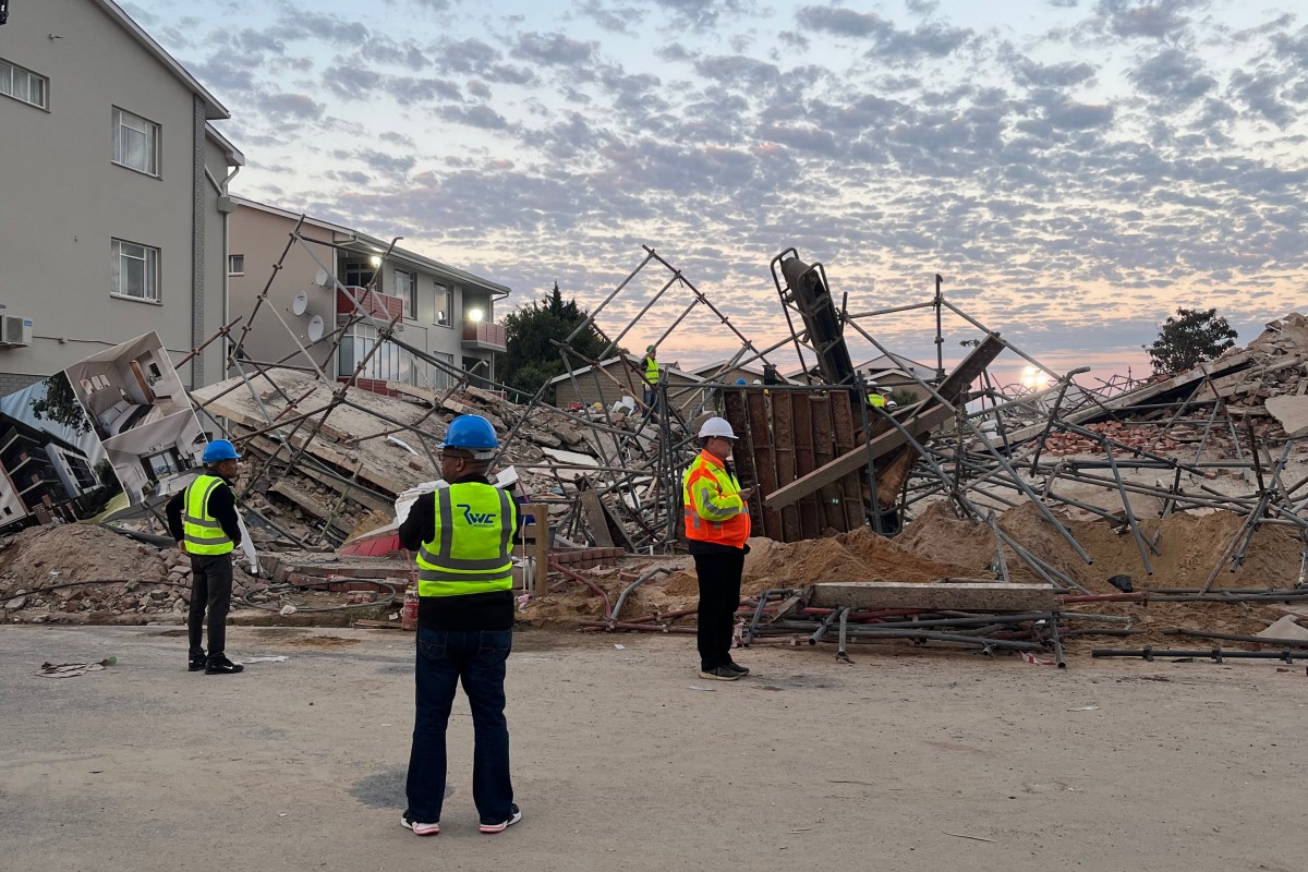 Officials are seen at the scene of a collapsed building in George on May 7, 2024. Photo by Willie van Tonder / AFP

