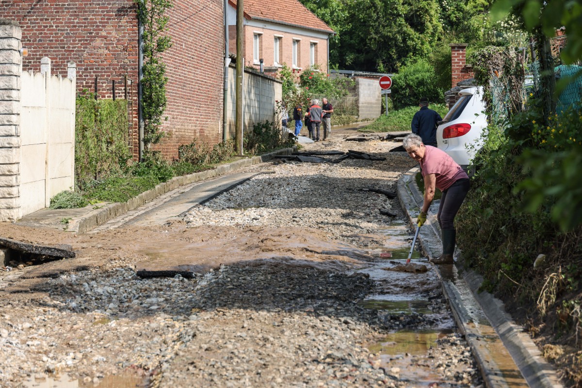 A resident tries to clean the road from debris in the small town of Sailly Lorette, after violent storms and torrential rain hit the north of France, causing homes to flood and mudslides to pour down streets, in Somme department, northern France, on May 22, 2024. (Photo by Denis CHARLET / AFP)
