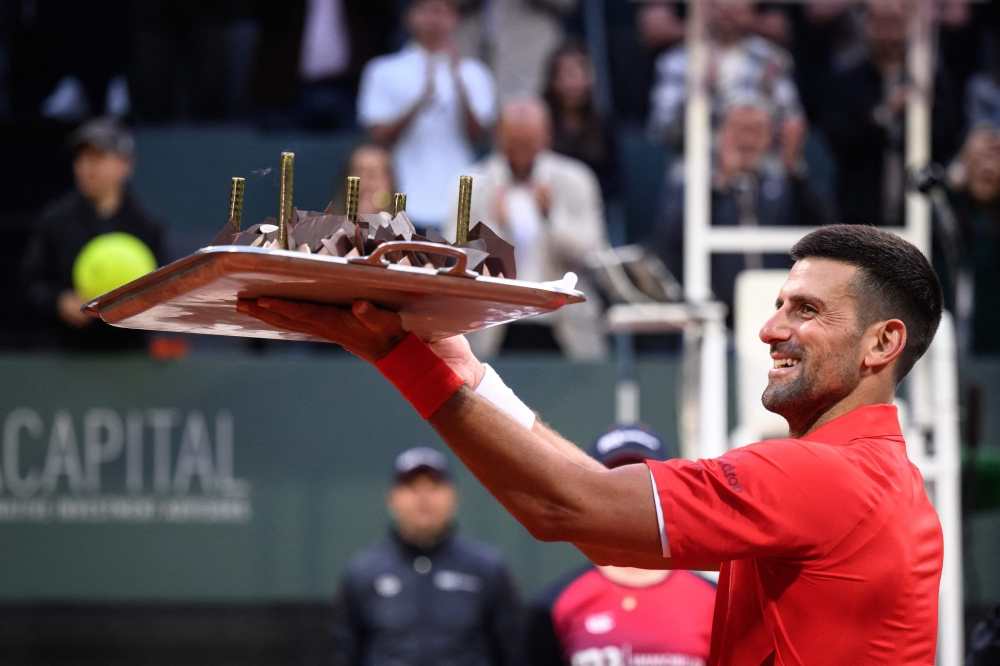 Serbia's Novak Djokovic reacts with his birthday cake after winning his ATP 250 Geneva Open tennis tournament single match against Germany's Yannick Hanfmann, in Geneva, on May 22, 2024. (Photo by Fabrice Coffrini / AFP)