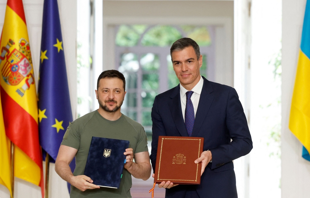 Ukraine's President Volodymyr Zelensky and Prime Minister Pedro Sanchez pose for photographs after signing a security deal at La Moncloa Palace in Madrid on May 27, 2024. (Photo by Oscar Del Pozo / AFP)
 