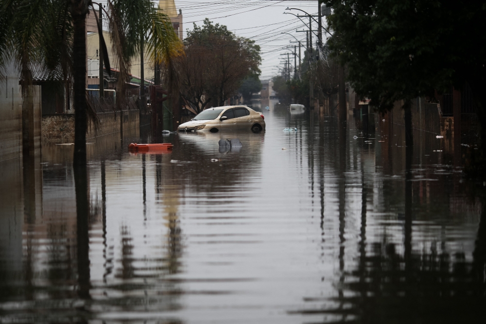 A car is partially submerged in a flooded street in the Sarandi neighborhood, one of the hardest hit by the heavy rains in Porto Alegre, Rio Grande do Sul state, Brazil, on May 27, 2024. Photo by Anselmo Cunha / AFP
