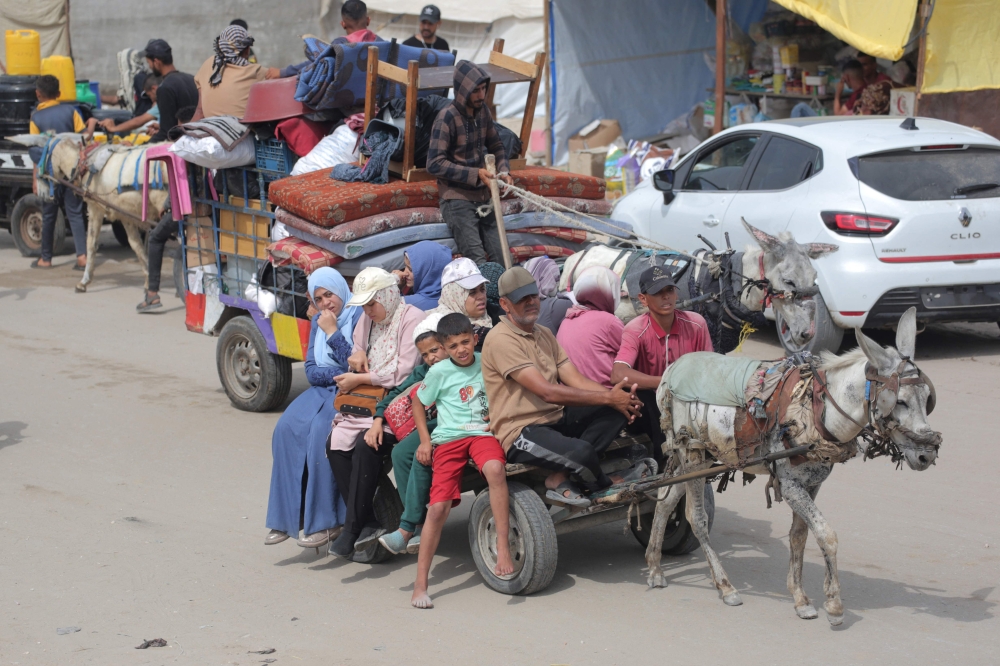 Palestinians fleeing unsafe areas in Rafah arrive with their belongings on a donkey-cart in Khan Yunis. (Photo by Bashar Taleb / AFP)