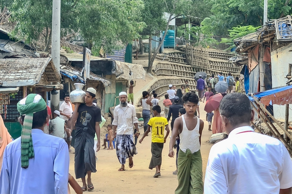 This photo taken on May 24, 2024 shows Rohingya refugees walking down a path at a Rohingya refugee camp in Ukhia in Bangladesh's southeastern Cox's Bazar district. (Photo by AFP) 