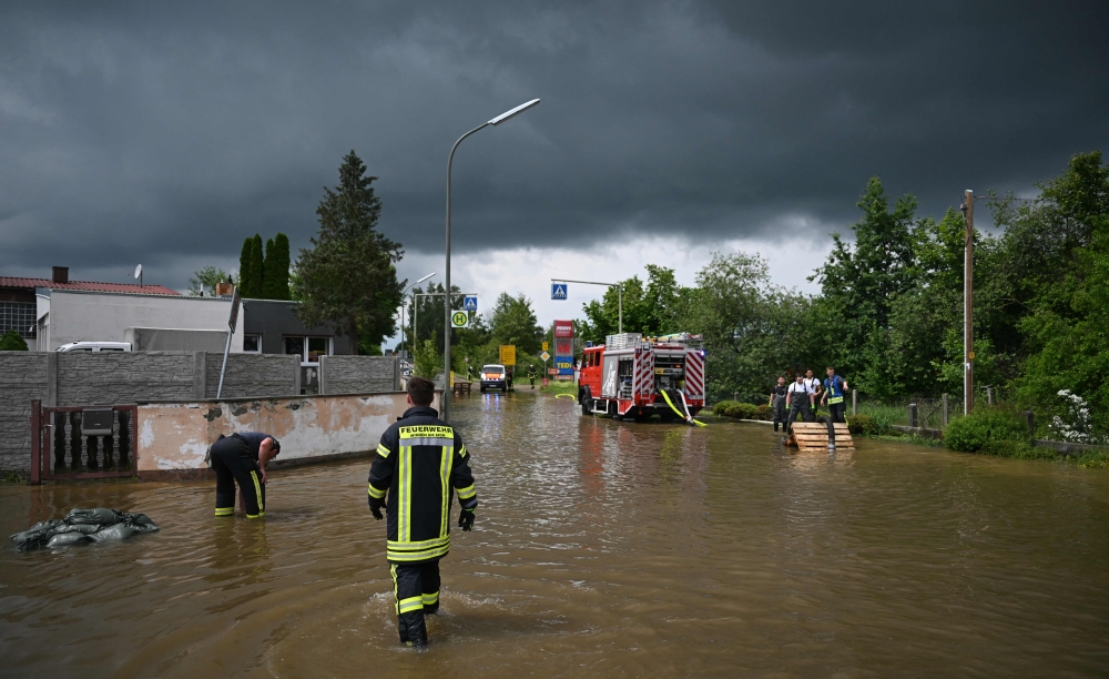 Firefighters work on a flooded street in Baar-Ebenhausen on June 2, 2024. Photo by LUKAS BARTH / AFP