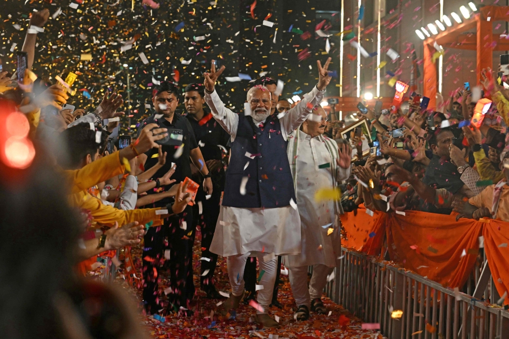 India's Prime Minister Narendra Modi flashes victory sign as he arrives at the Bharatiya Janata Party (BJP) headquarters to celebrate the party's win in country's general election, in New Delhi on June 4, 2024. (Photo by Arun Sankar / AFP)

