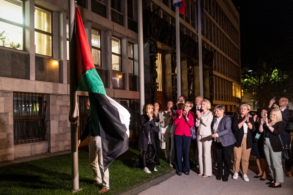 People hang a Palestinian flag in front of the Parliament building after the National Assembly recognised the Palestinian state following a parliamentary vote in Ljubljana, on June 4, 2024. Photo by AFP.