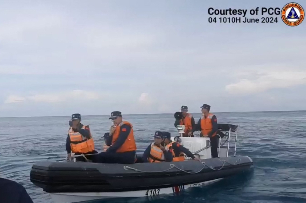 This handout photo grabbed from a video released by the Philippine Coast Guard on June 7, 2024 shows Chinese Coast Guard personnel aboard their rigid inflatable boat, blocking a Philippine Coast Guard rigid inflatable boat carrying marine scientists in the waters of the South China Sea. Photo by Mahmoud RIZK / Philippine Coast Guard (PCG) / AFP