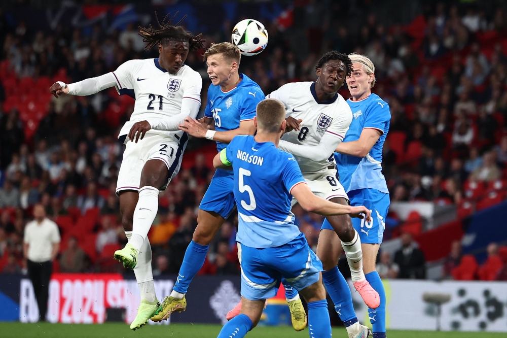England's midfielder #21 Eberechi Eze (left) wins a header from Iceland's midfielder #15 Bjarki Bjarkason (2nd left) during the International friendly football match between England and Iceland at Wembley Stadium in London on June 7, 2024. (Photo by Henry Nicholls / AFP)