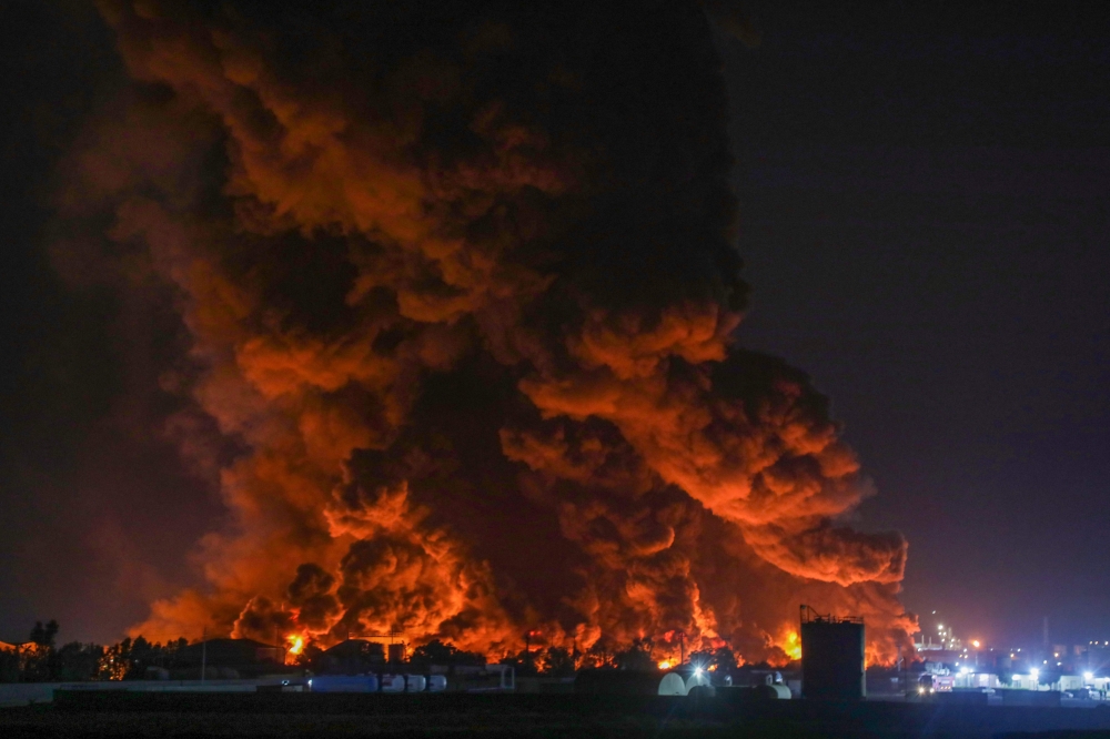 Flames rise after a massive fire broke out at the asphalt storage facility of an oil refinery in Arbil on Jun 13, 2024. (Photo by Safin Hamid / AFP)