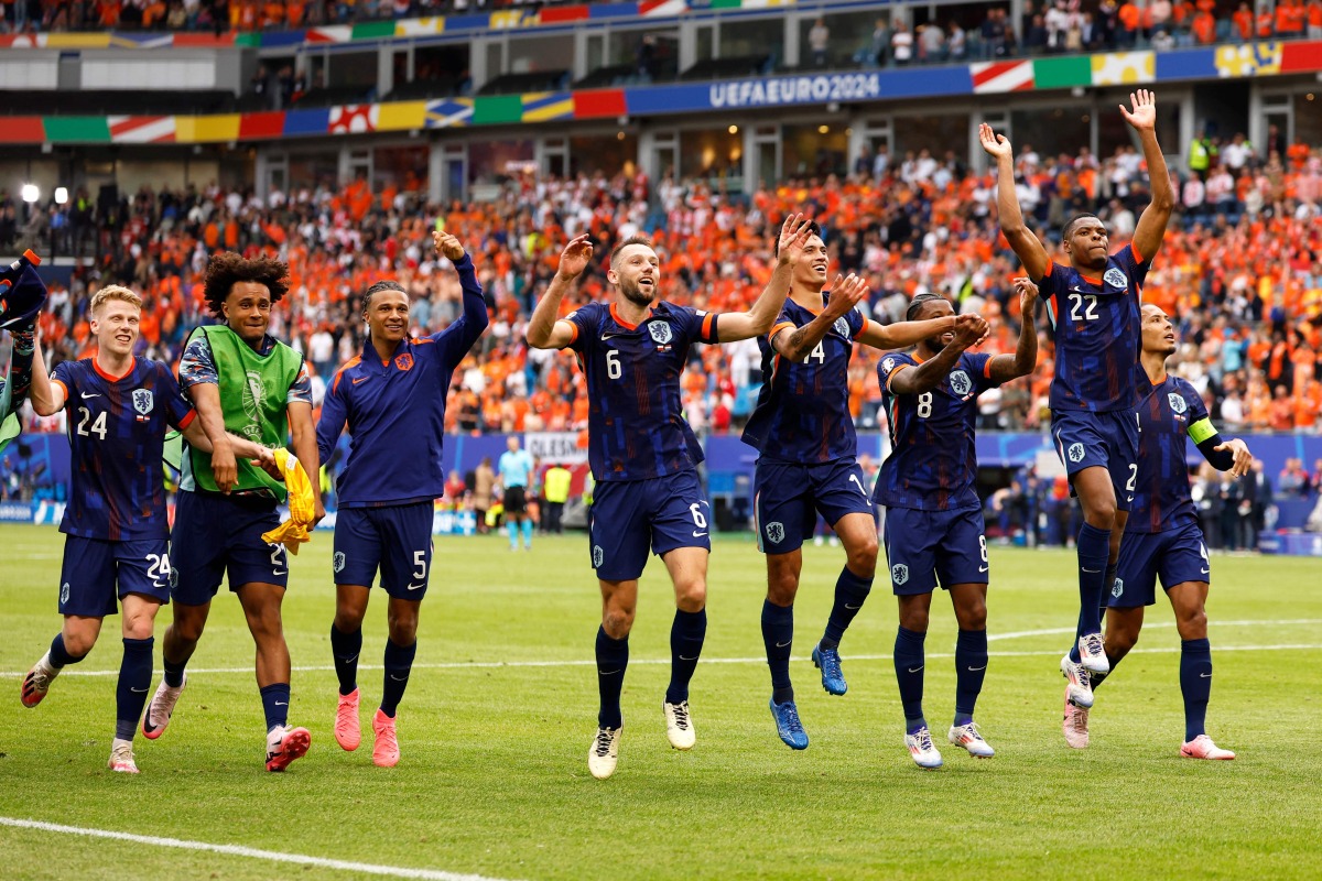 Netherlands' players celebrate after winning the UEFA Euro 2024 Group D football match between Poland and the Netherlands at the Volksparkstadion in Hamburg on June 16, 2024. (Photo by Odd ANDERSEN / AFP)