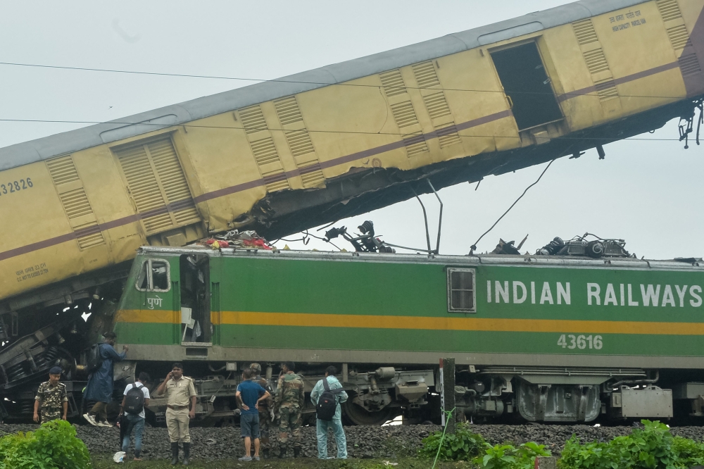 Railway workers help to restore services at the accident site following a collision between a passenger and a goods train in Nirmaljote, near Rangapani station in India's West Bengal state, on June 17, 2024. (Photo by DIBYANGSHU SARKAR / AFP)
