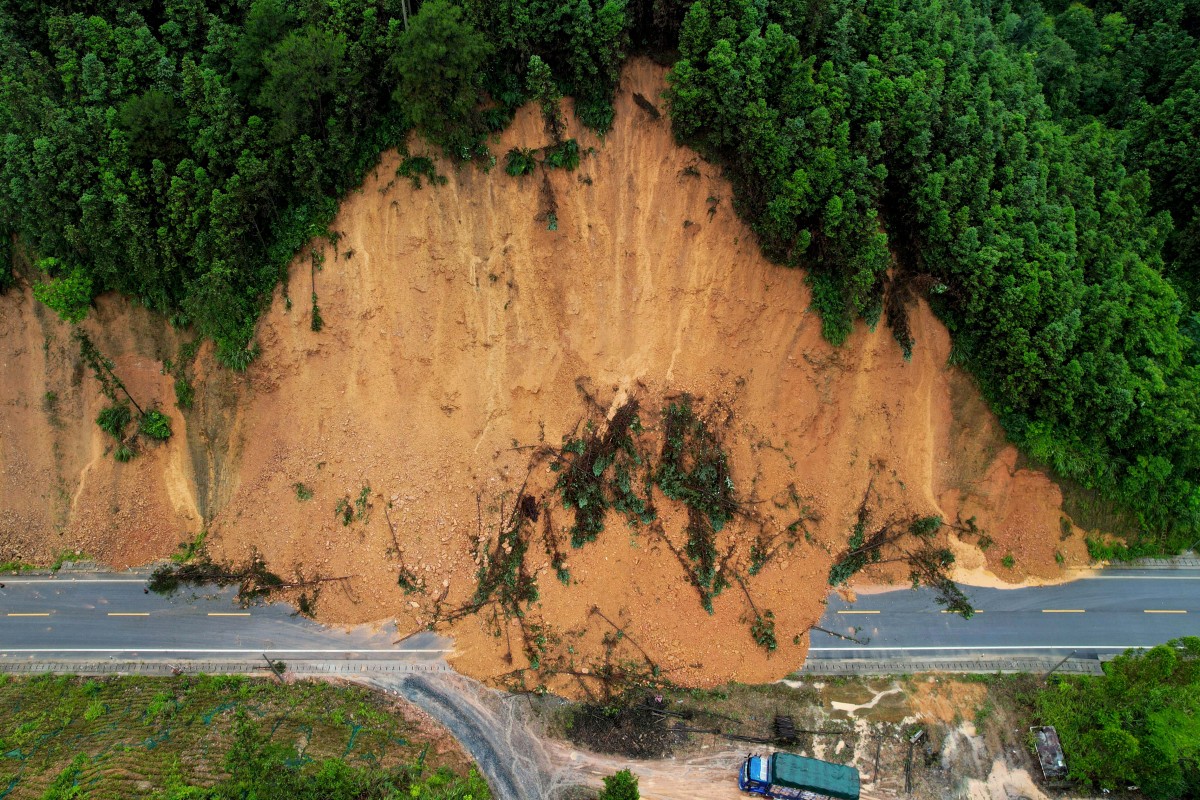This aerial photo shows a truck driving past a landslide site after storms in Liuzhou, in southwestern China's Guangxi province on June 13, 2024. Photo by AFP.
