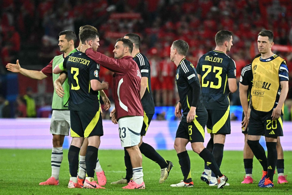 Scotland's defender #03 Andrew Robertson shakes hands with Switzerland's midfielder #23 Xherdan Shaqiri at the end of the UEFA Euro 2024 Group A football match between Scotland and Switzerland at the Cologne Stadium in Cologne on June 19, 2024. (Photo by JAVIER SORIANO / AFP)

