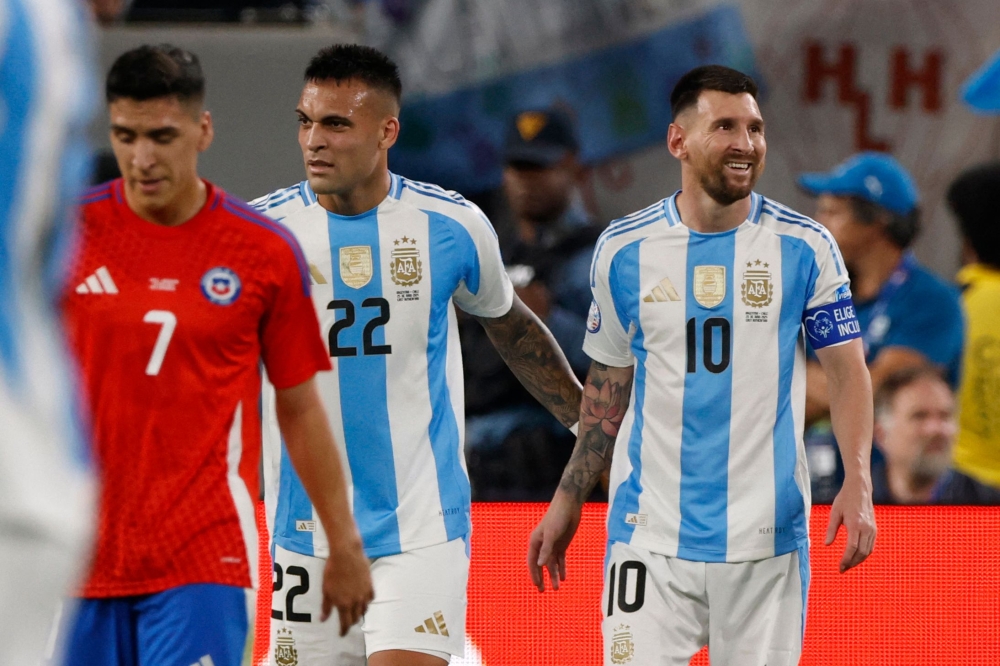 Argentina's forward #10 Lionel Messi (R) and Argentina's forward #22 Lautaro Martinez react at the end of the Conmebol 2024 Copa America tournament group A football match on June 25, 2024. (Photo by Eduardo Munoz / AFP)