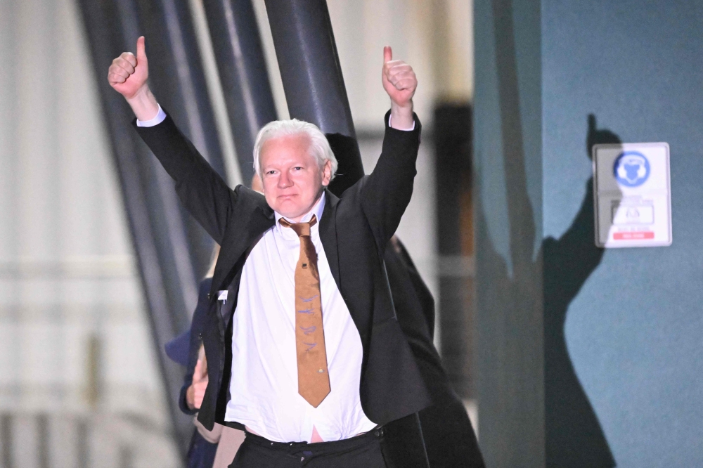 WikiLeaks founder Julian Assange gives thumbs up after arriving at Canberra Airport in Canberra on June 26, 2024, after he pleaded guilty at a US court in Saipan to a single count of conspiracy to obtain and disseminate US national defence information. (Photo by William West / AFP)