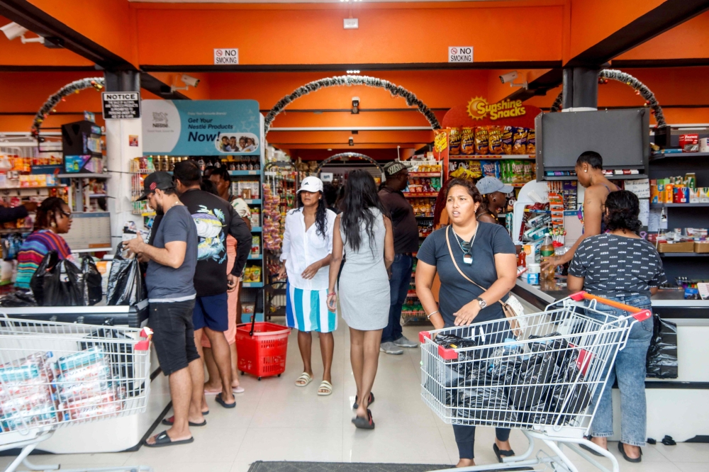 People shop groceries at a supermarket in Scarborough, Trinidad and Tobago, as they prepare for the arrival of Hurricane Beryl on June 30, 2024. (Photo by Clement George Williams / AFP)
