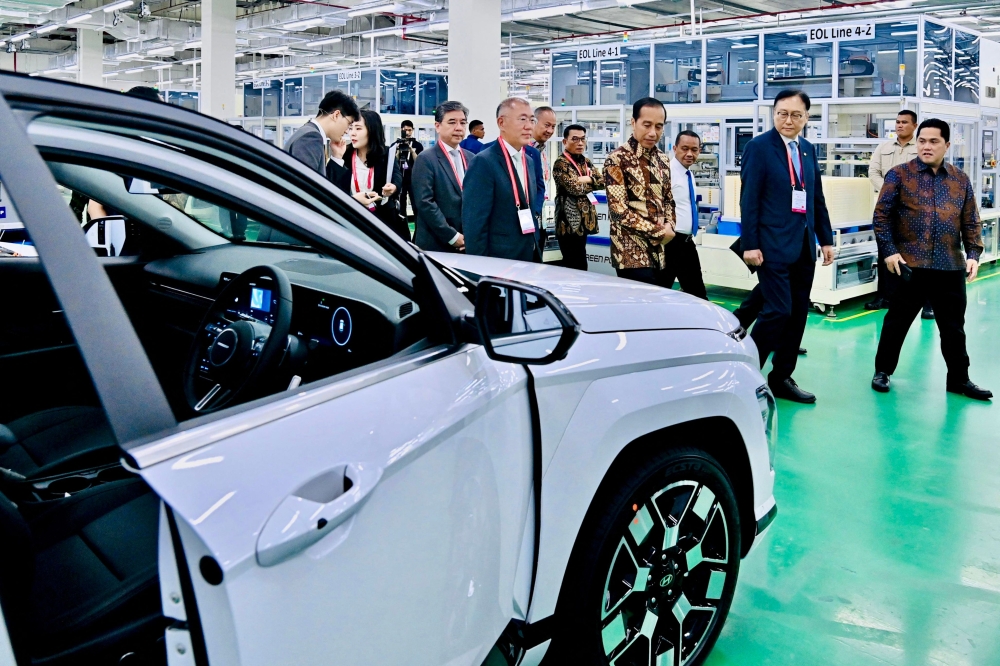 Indonesian President Joko Widodo (centre R) walking with Hyundai Motor Group Executive Chairman Chung Eui-sun (C) during an inspection of the battery and electric vehicle manufacturing plant by PT Hyundai LG Indonesia-Green Power in Karawang, West Java. (Photo by Handout / Indonesian Presidential Palace/ AFP) 