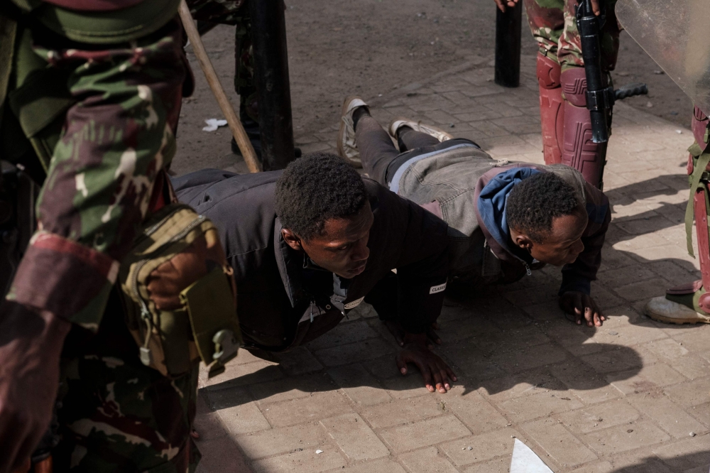 Detained protesters are seen doing push ups during an anti-government demonstration in downtown Nairobi, on July 2, 2024. (Photo by Kabir Dhanji / AFP)