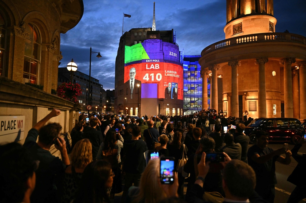 An exit poll predicting that the Labour Party led by Keir Starmer will win 410 seats in Britain's general election is projected onto BBC Broadcasting House in London on July 4, 2024. Labour is set for landslide win in UK election, exit polls showed. (Photo by Oli SCARFF / AFP)

