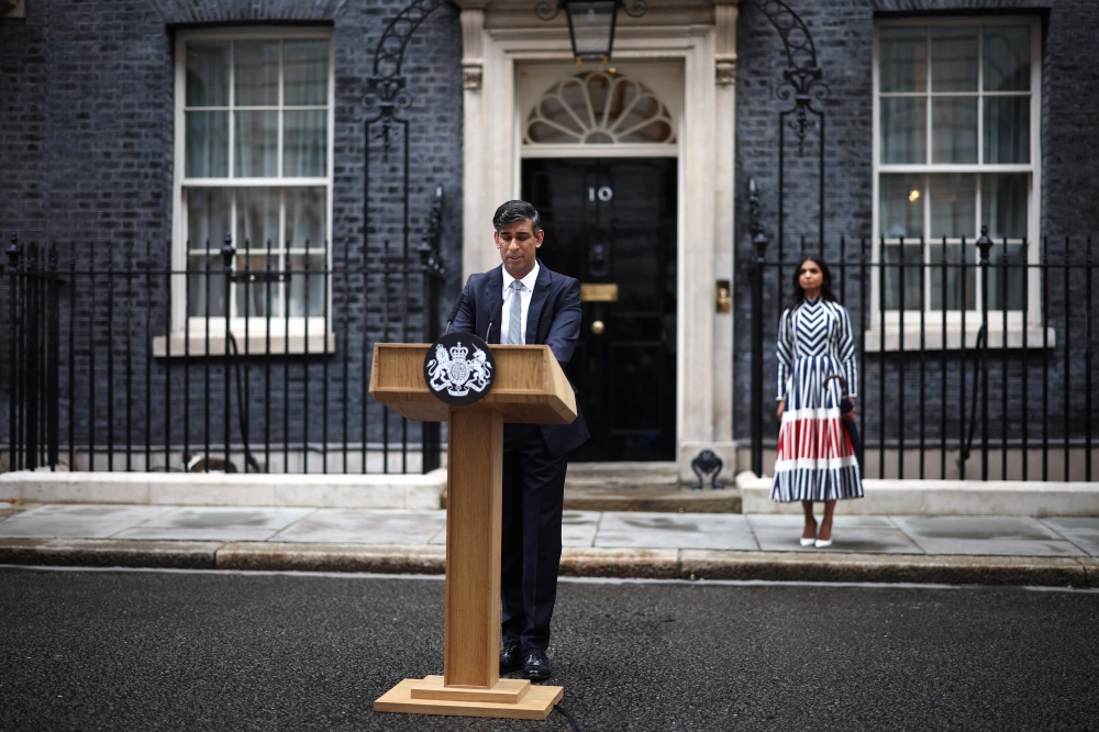 Britain's outgoing Prime Minister and leader of the Conservative party, Risihi Sunak, watched by his wife Akshata Murty, delivers a statement after his general election defeat, outside 10 Downing Street in London on July 5, 2024, a day after Britain held a general election. (Photo by Henry Nicholls / AFP)