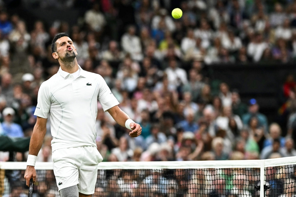 Serbia's Novak Djokovic celebrates winning the second set against Denmark's Holger Rune during their men's singles tennis match on the eighth day of the 2024 Wimbledon Championships at The All England Lawn Tennis and Croquet Club in Wimbledon, southwest London, on July 8, 2024. (Photo by Ben Stansall / AFP) / RESTRICTED TO EDITORIAL USE
