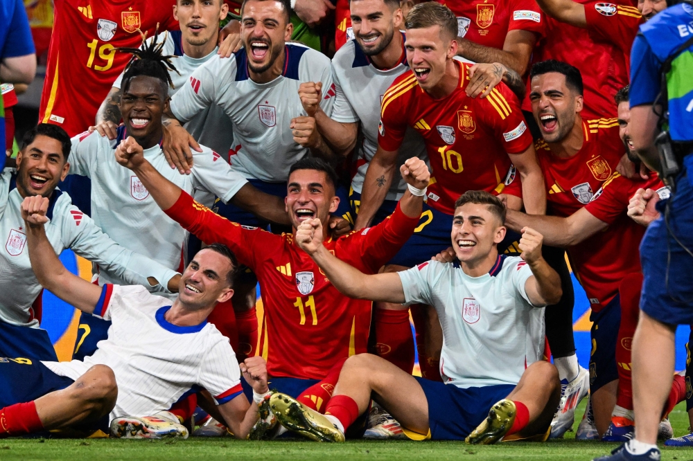Spain's players celebrate after winning the UEFA Euro 2024 semi-final football match between the Spain and France at the Munich Football Arena in Munich on July 9, 2024. (Photo by Odd Andersen / AFP)