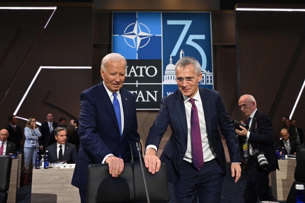 US President Joe Biden (left) and NATO Secretary-General Jens Stoltenberg take their seats at a meeting of the NATO-Ukraine Council during the NATO 75th anniversary summit at the Walter E. Washington Convention Center in Washington, DC, on July 11, 2024. (Photo by Saul Loeb / AFP)