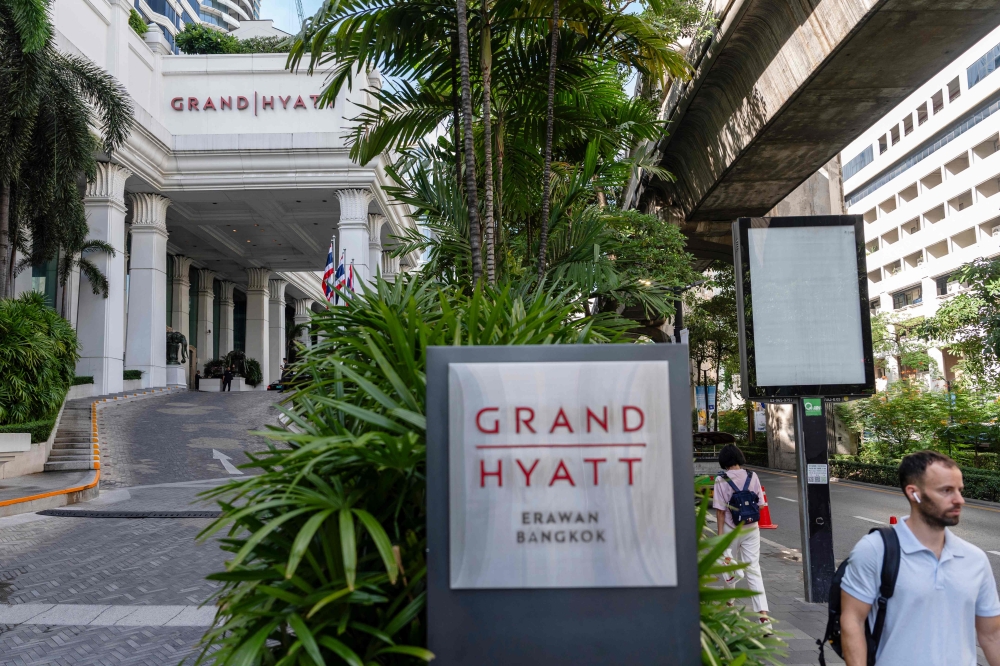 People walk past the main entrance of the Grand Hyatt Erawan hotel in Bangkok on July 17, 2024. (Photo by Chanakarn Laosarakham / AFP)