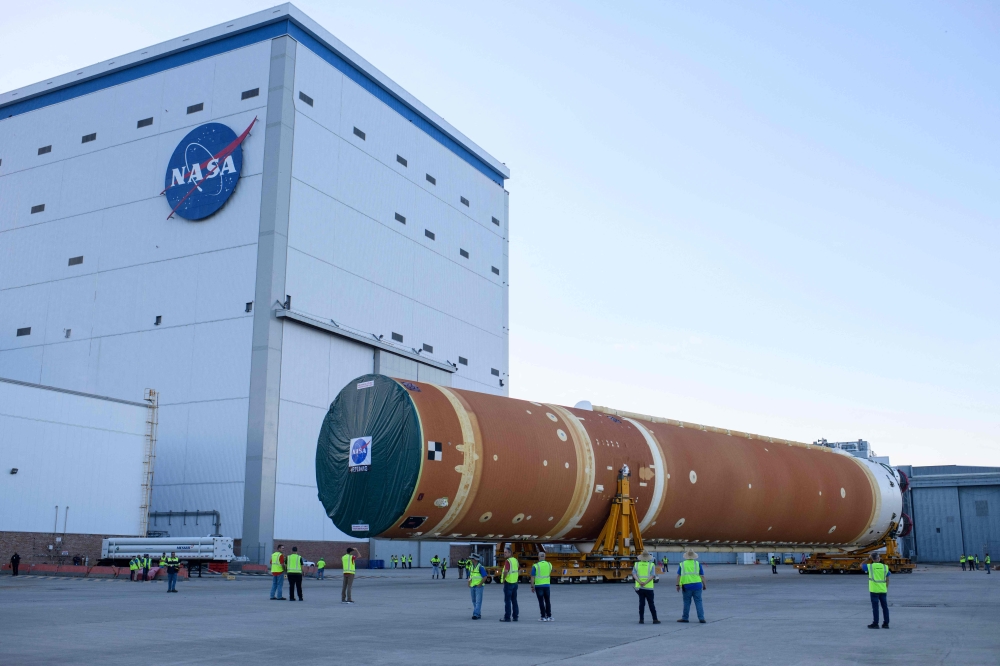 NASA employees watch as the Artemis II rocket core stage is wheeled out at the NASA Michoud Assembly Facility in New Orleans, Louisiana, on July 16, 2024. (Photo by Mark Felix / AFP)