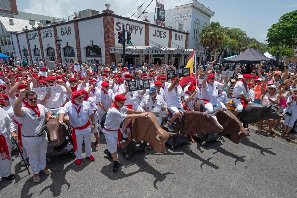 :In this photo released by the Florida Keys News Bureau, past winners and current contestants in the Hemingway Look-Alike Contest begin the 