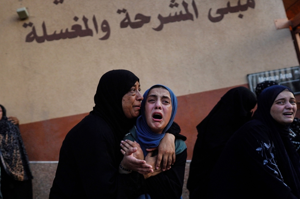 Palestinian women cry as killed members of the Abu Taha family are brought for burial, outside Nasser hospital in Khan Yunis following Israeli bombardment east of the city in the southern Gaza Strip on July 22, 2024. (Photo by Bashar Taleb / AFP)