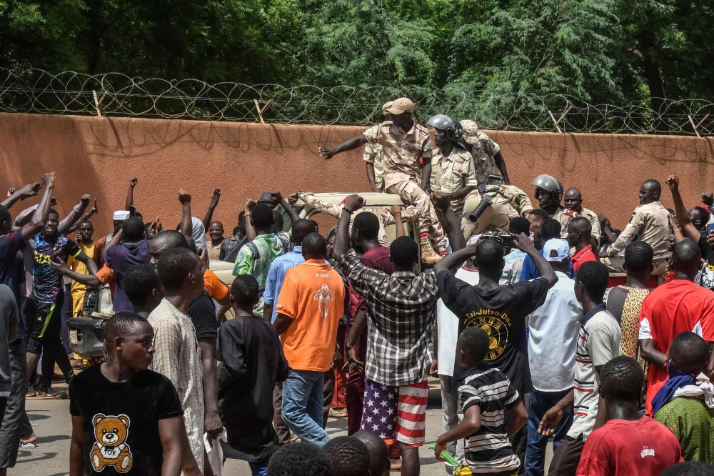 (FILES) Protesters cheer Nigerien troops as they gather in front of the French Embassy in Niamey during a demonstration that followed a rally in support of Niger's junta in Niamey on July 30, 2023. (Photo by AFP)
