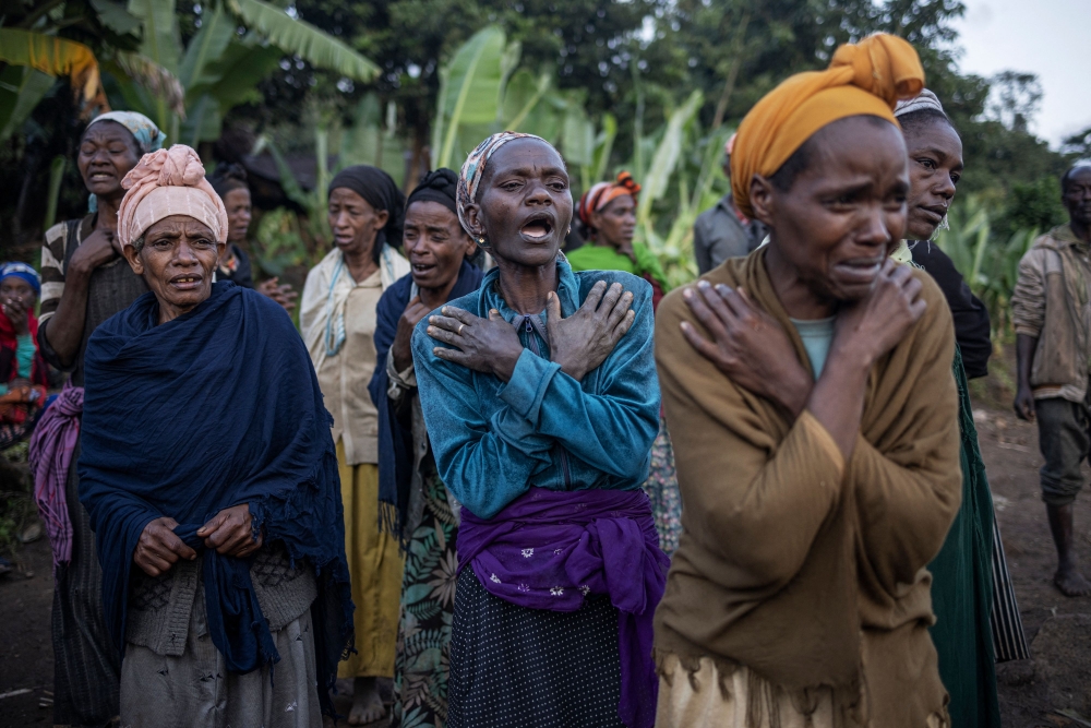 Women weep while residents and volunteers leave for the night after digging in the mud in search for survivors and bodies at the scene of a landslide in Gofa on July 24, 2024. Photo by Michele Spatari / AFP