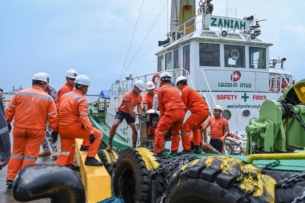 Coast guard personnel load the skimmers to be used in the oil spill response, at a port in Limay, Bataan on July 26, 2024. Photo by Jam Sta Rosa / AFP